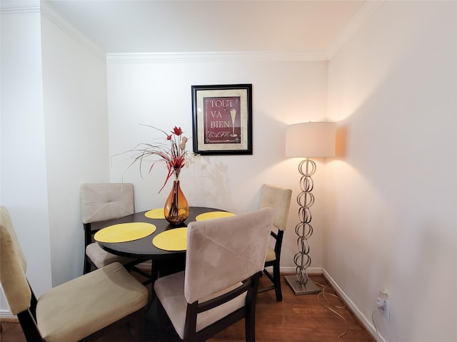 dining room with dark wood-type flooring and ornamental molding