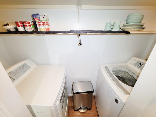 clothes washing area featuring hardwood / wood-style flooring and washing machine and clothes dryer