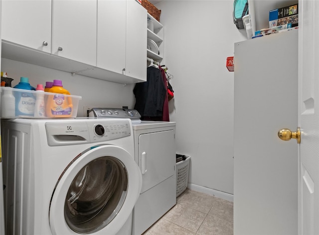 laundry room with separate washer and dryer, light tile patterned floors, and cabinets