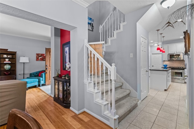 stairs featuring tile patterned flooring and ornamental molding