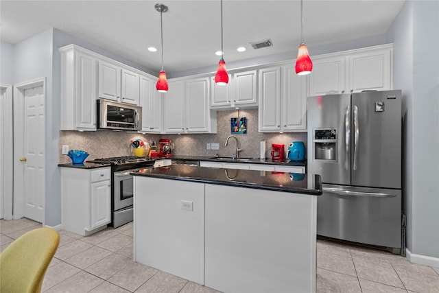 kitchen with light tile patterned floors, white cabinetry, stainless steel appliances, and hanging light fixtures