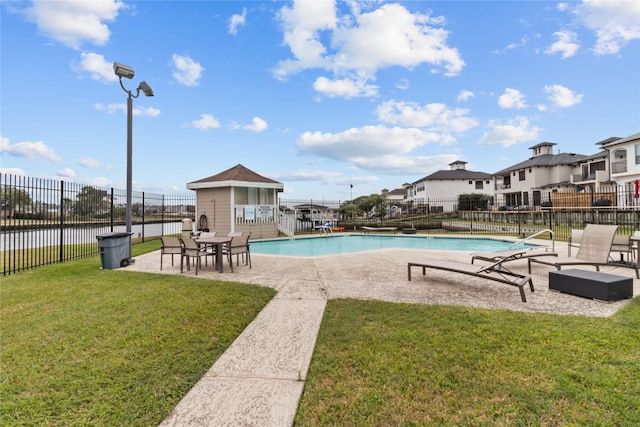 view of pool with a patio and a lawn