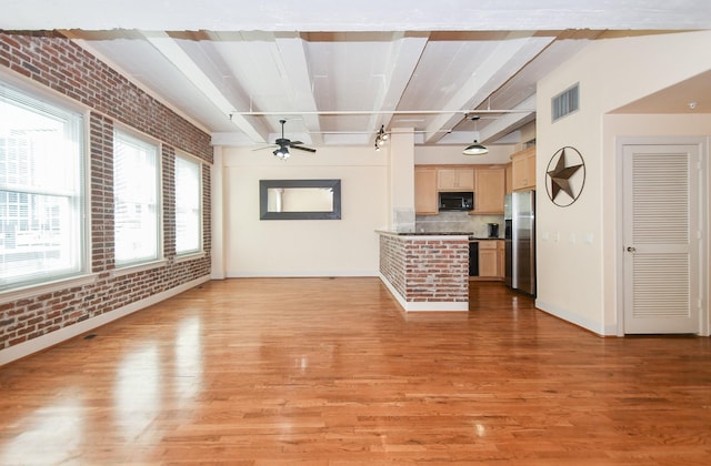 unfurnished living room with ceiling fan, light hardwood / wood-style floors, beam ceiling, and brick wall