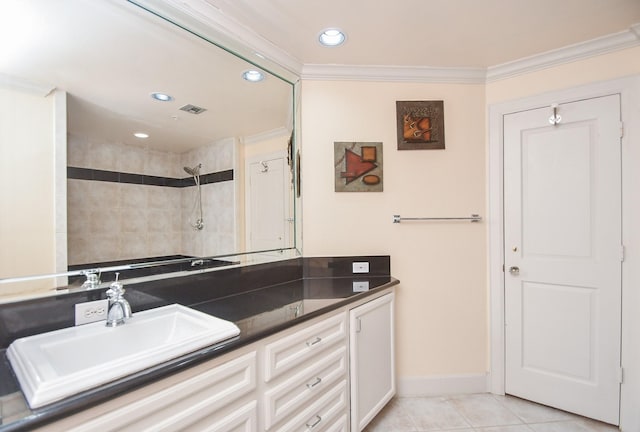 bathroom featuring a tile shower, vanity, tile patterned floors, and ornamental molding