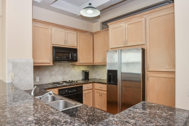 kitchen featuring dark stone counters, sink, black appliances, and decorative light fixtures