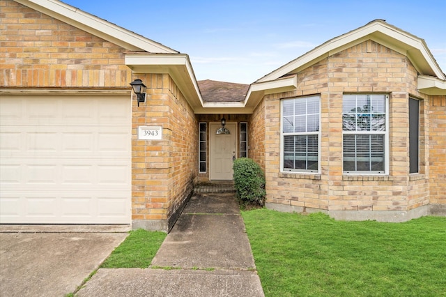 entrance to property featuring a yard and a garage