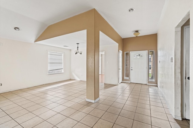 entrance foyer with a notable chandelier, light tile patterned flooring, and lofted ceiling