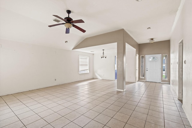 unfurnished living room with ceiling fan with notable chandelier, light tile patterned floors, a wealth of natural light, and vaulted ceiling