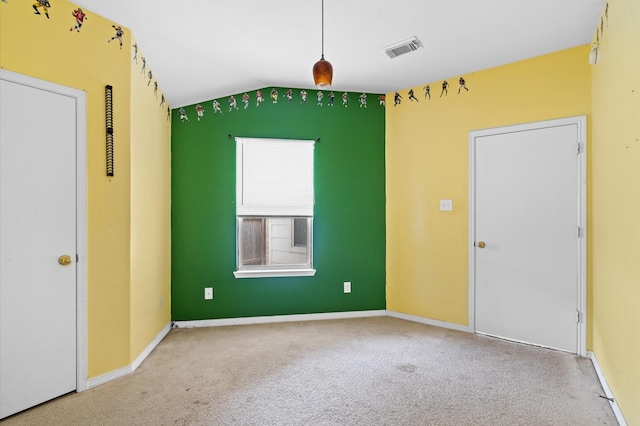 spare room featuring carpet flooring and lofted ceiling