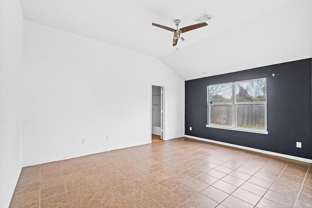 empty room featuring ceiling fan, light tile patterned floors, and vaulted ceiling