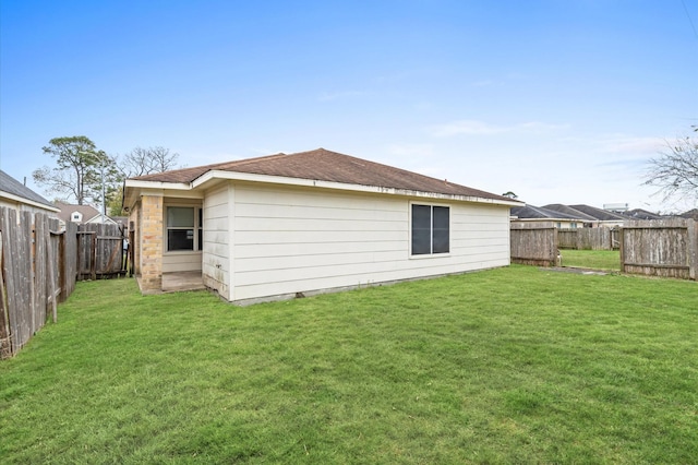 rear view of property with a yard