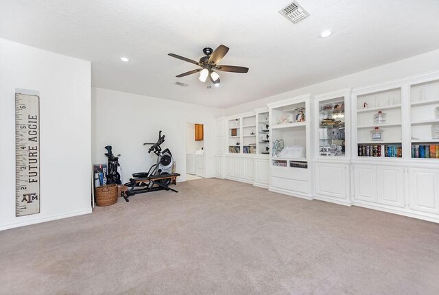 workout room featuring ceiling fan and light carpet