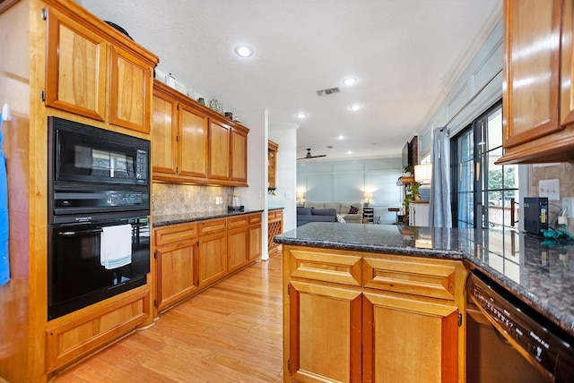 kitchen featuring ceiling fan, dark stone countertops, decorative backsplash, black appliances, and light wood-type flooring