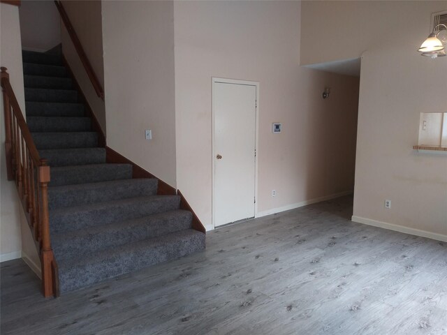 stairs featuring hardwood / wood-style floors and a high ceiling