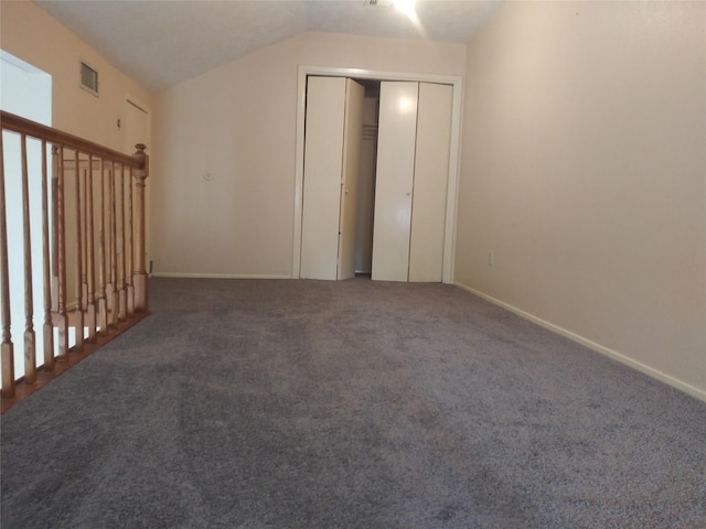 interior space featuring dark carpet and vaulted ceiling