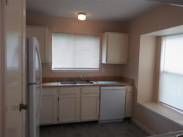 kitchen with white cabinetry, dark hardwood / wood-style flooring, white appliances, and sink