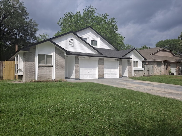 view of front of home featuring fence, an attached garage, driveway, brick siding, and a front yard