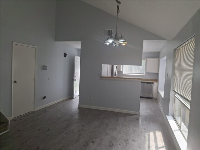 interior space with white cabinets, stainless steel appliances, visible vents, a notable chandelier, and high vaulted ceiling