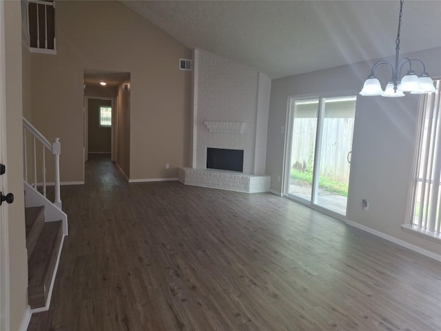 unfurnished living room with a chandelier, lofted ceiling, a wealth of natural light, and stairs