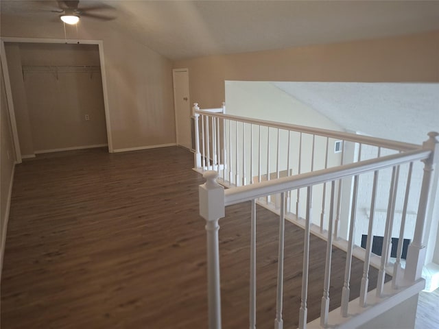 hallway featuring an upstairs landing, lofted ceiling, wood finished floors, and baseboards