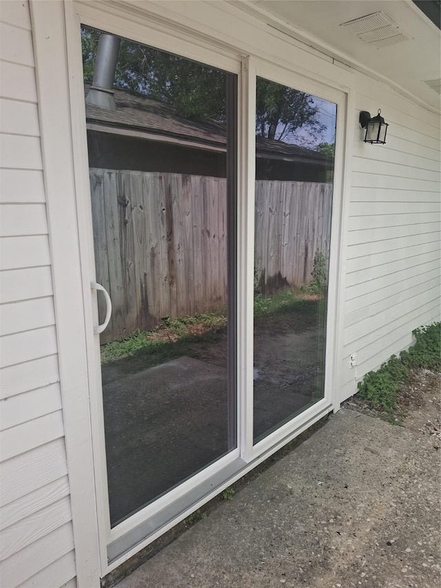 view of exterior entry featuring fence