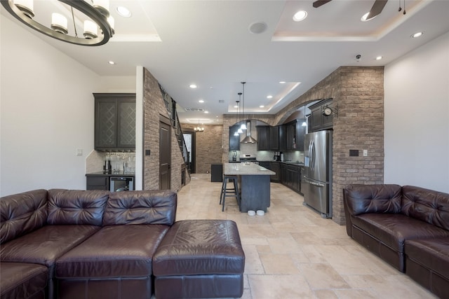 living room with ceiling fan and a tray ceiling