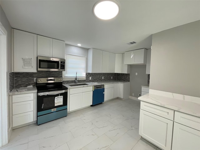 kitchen featuring decorative backsplash, sink, white cabinetry, and stainless steel appliances