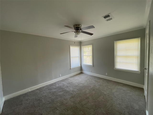 empty room featuring dark colored carpet, ceiling fan, and ornamental molding