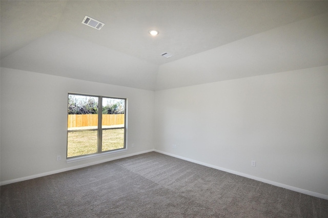 carpeted spare room with vaulted ceiling