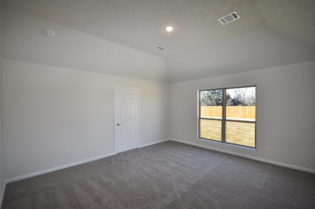 carpeted empty room with vaulted ceiling