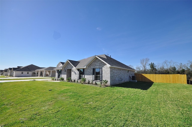 view of front of house featuring cooling unit and a front yard