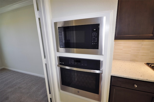 interior details with carpet, dark brown cabinets, oven, and built in microwave