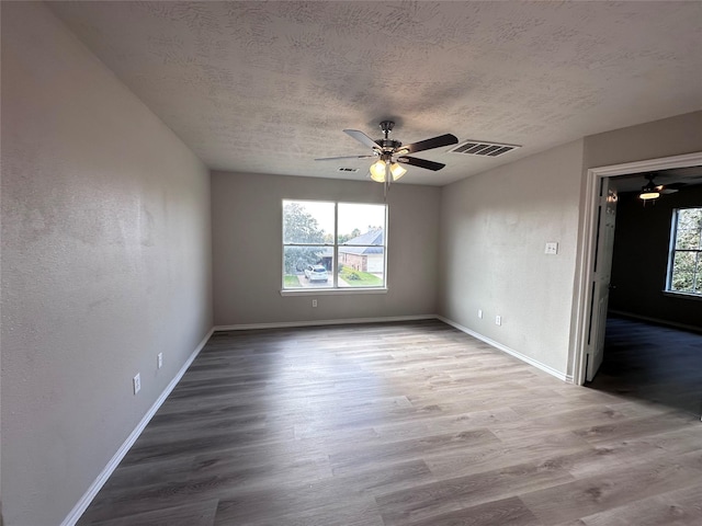 spare room featuring ceiling fan, hardwood / wood-style flooring, and a textured ceiling