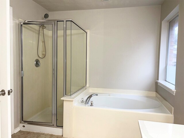 bathroom featuring independent shower and bath, a textured ceiling, and plenty of natural light