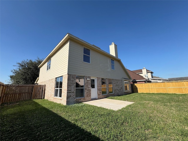 rear view of property with a lawn and a patio