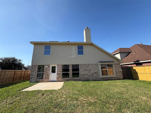 back of house featuring a patio area and a lawn