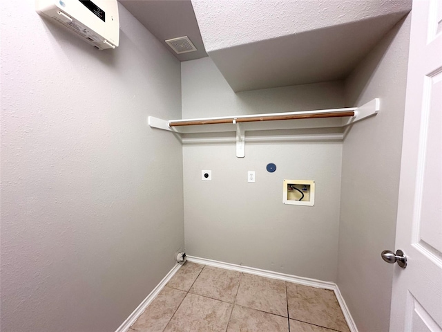 washroom featuring a wall mounted AC, hookup for a washing machine, light tile patterned floors, electric dryer hookup, and a textured ceiling