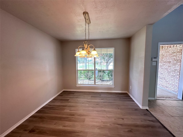 unfurnished dining area with an inviting chandelier and dark hardwood / wood-style floors