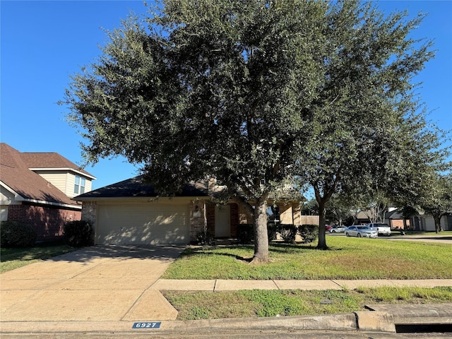 view of property hidden behind natural elements with a front yard and a garage