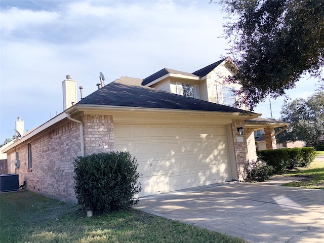 view of side of property with cooling unit and a garage