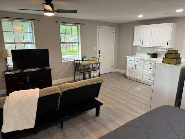 living room with ceiling fan and light hardwood / wood-style floors