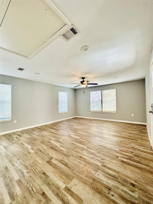 spare room featuring ceiling fan, a healthy amount of sunlight, and wood-type flooring