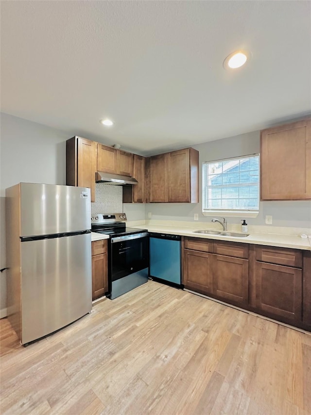 kitchen featuring sink, stainless steel appliances, light hardwood / wood-style flooring, and tasteful backsplash