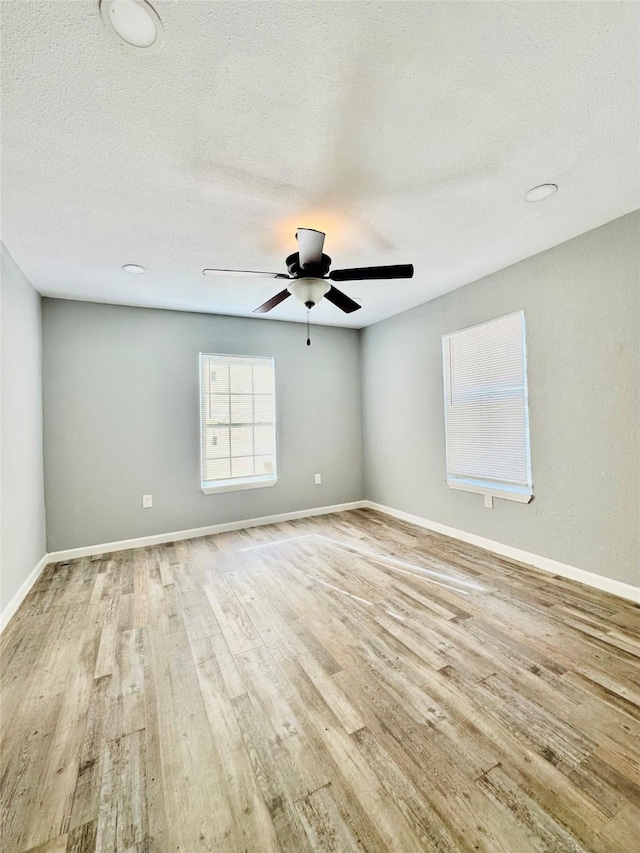 empty room featuring a textured ceiling, ceiling fan, and light hardwood / wood-style flooring