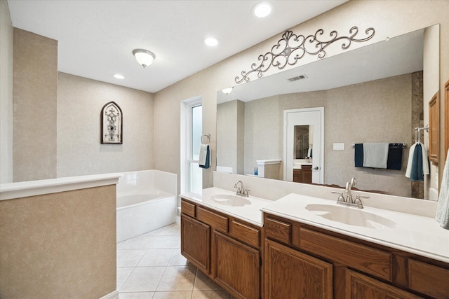 bathroom with a bath, vanity, and tile patterned floors