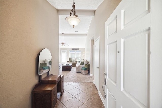 entrance foyer with carpet flooring, ceiling fan, and a textured ceiling