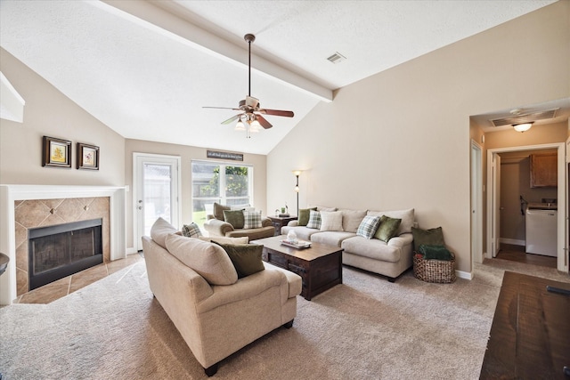 living room featuring ceiling fan, vaulted ceiling with beams, a high end fireplace, light colored carpet, and a textured ceiling