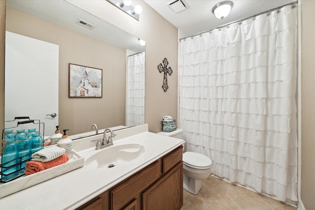 bathroom featuring tile patterned floors, vanity, and toilet