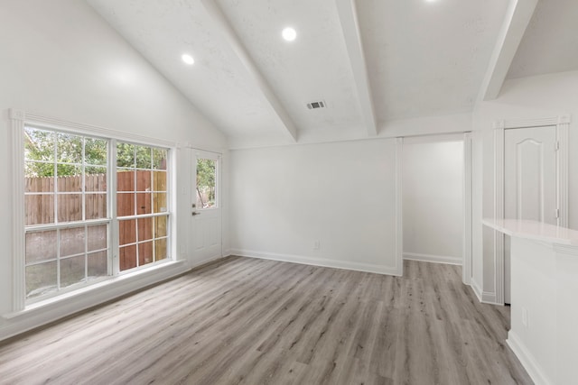 interior space featuring lofted ceiling with beams and light wood-type flooring