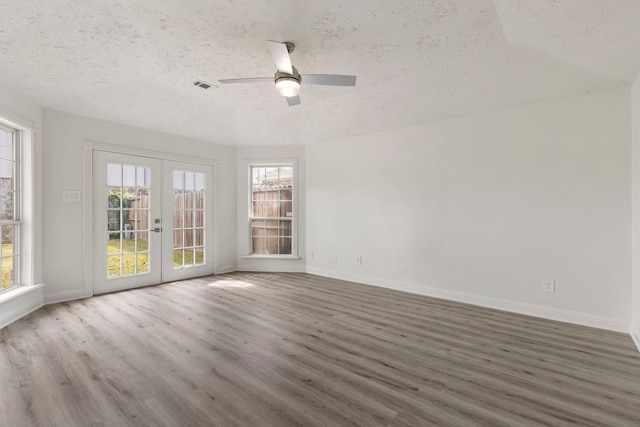 empty room with french doors, dark hardwood / wood-style flooring, a textured ceiling, and ceiling fan